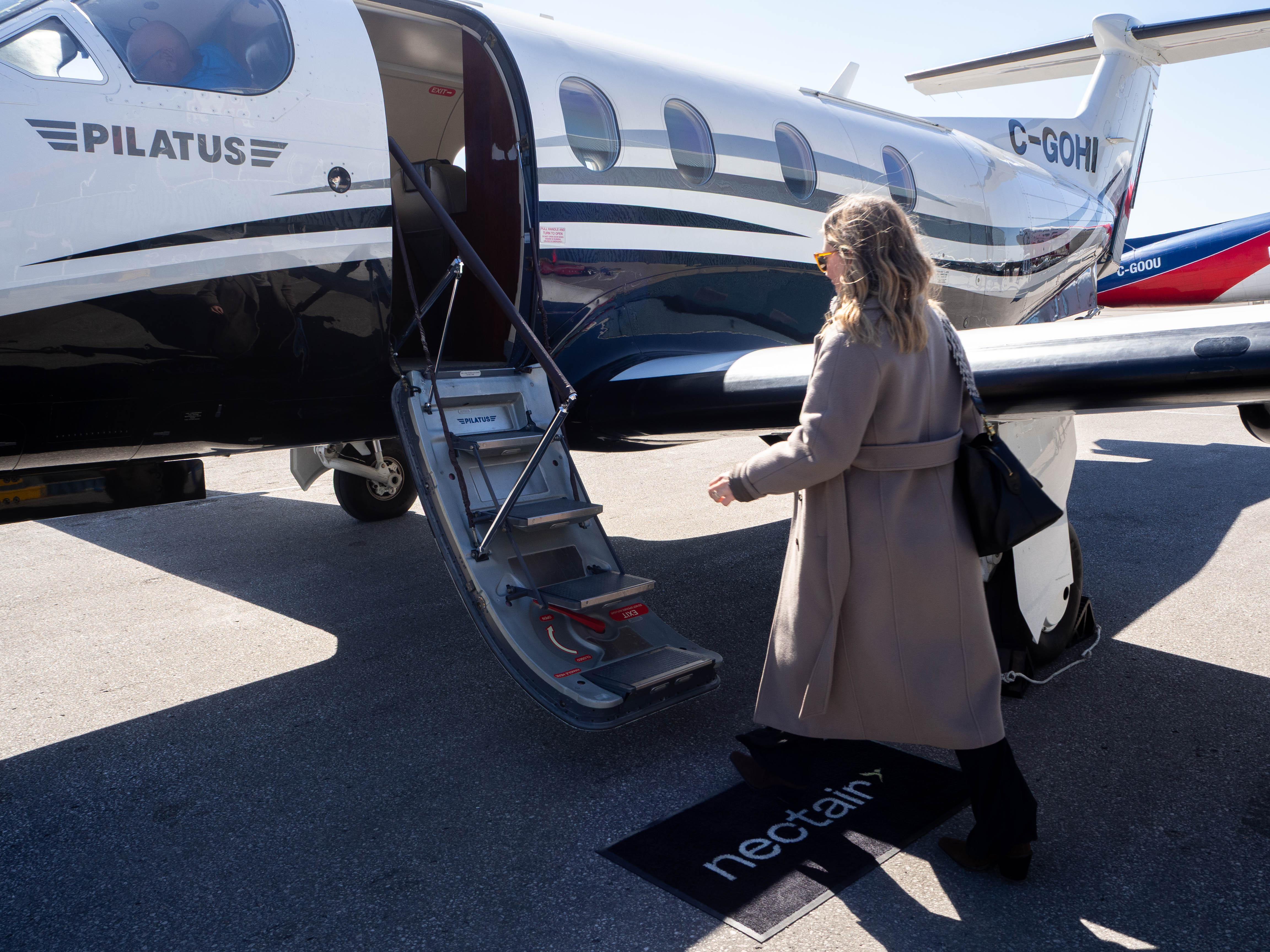 A NectAir passenger boarding the Pilatus PC-12